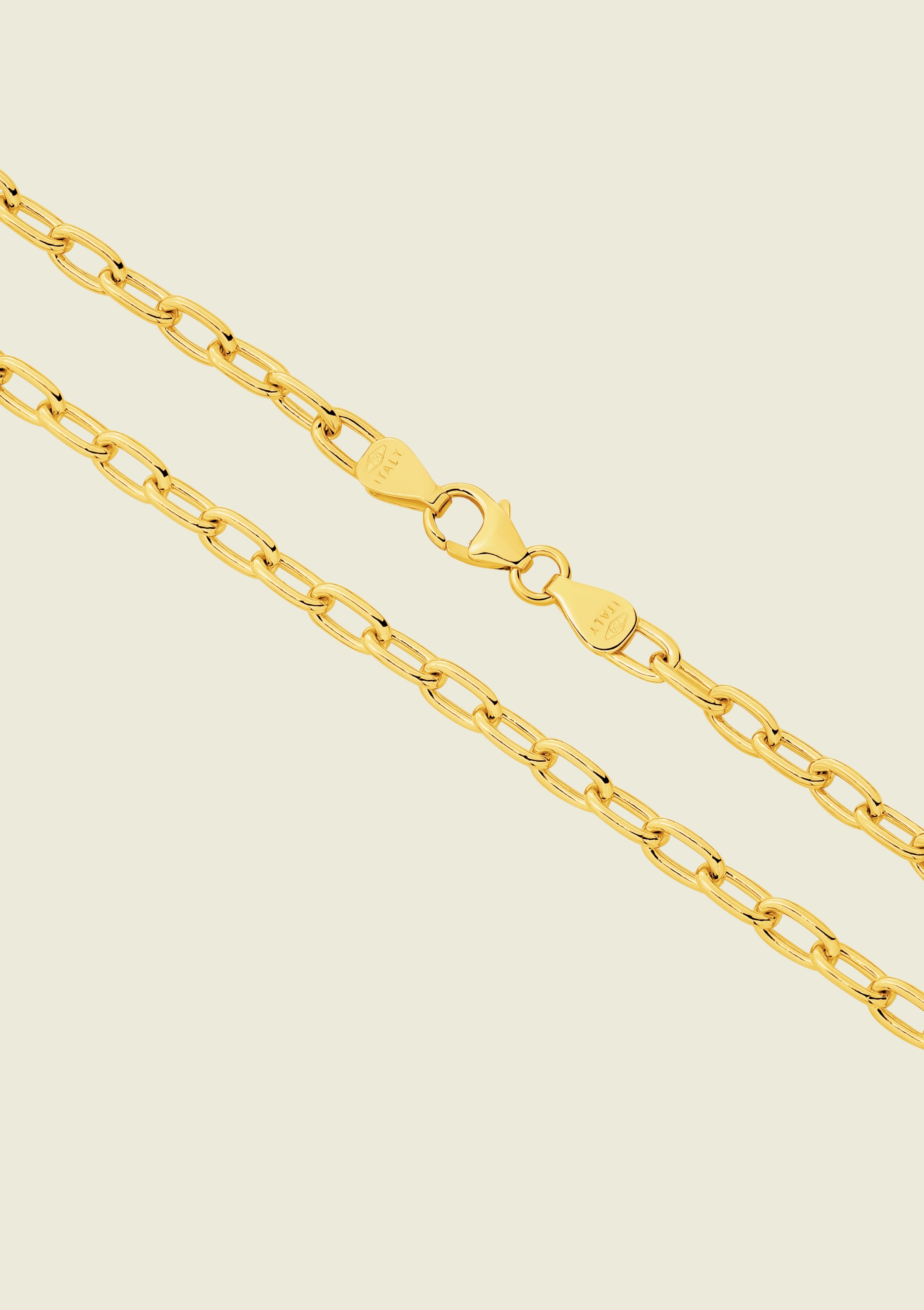 Gold chain necklace on a beige background