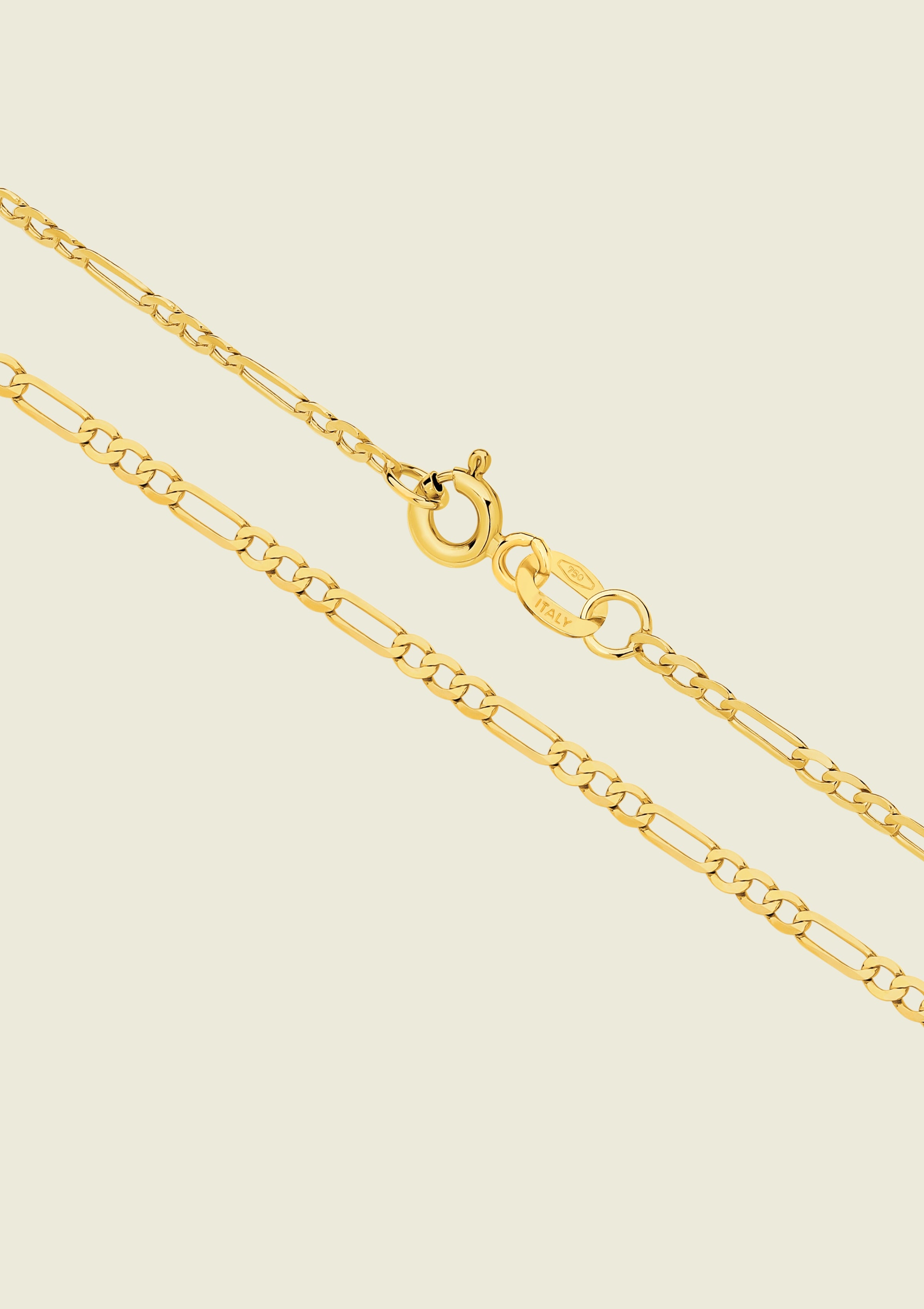 Gold chain necklace on a beige background