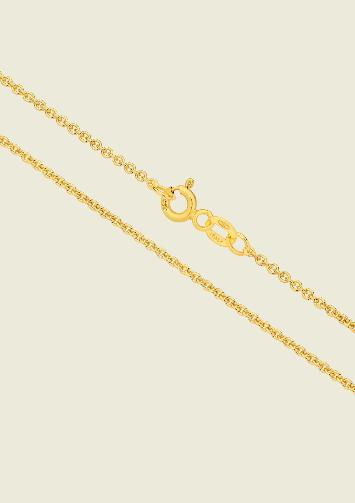 Gold chain necklace on a beige background